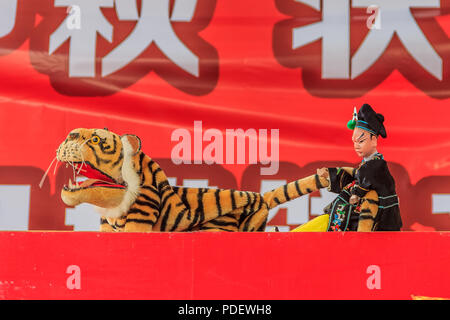 Xiamen, Cina - 14 Settembre 2013: Cinese burattinaio eseguendo una mano uno spettacolo di burattini su Wu Song uccidendo l'uomo-eating tiger basato su un antico Chi Foto Stock