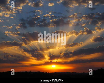 Cielo colorato con altocumulus tramonto nuvole crepuscolari con raggi di luce visto a Bourne End, vicino a Hemel Hempstead, Hertfordshire in tarda estate. Foto Stock