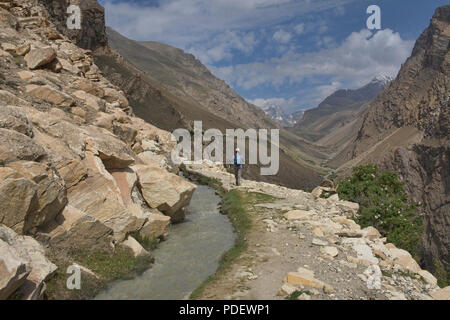 Trekking lungo un canale di irrigazione di Engel's Peak, Langar, Tagikistan Foto Stock