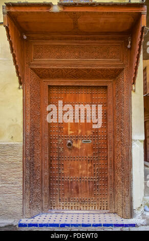 Vecchio di Legno complessamente intarsiato, studded porta e porta-cornice di una tradizionale casa marocchina in Fes, Marocco Foto Stock