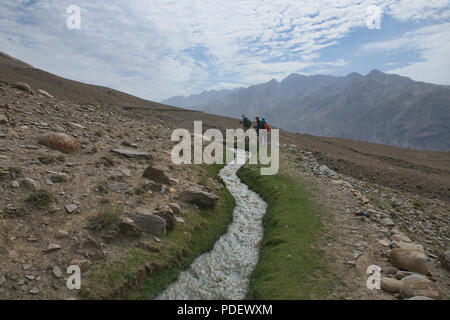 Trekking lungo un canale di irrigazione di Engel's Peak, Langar, Tagikistan Foto Stock