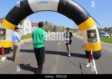 Un partecipante attraversa la linea del traguardo durante la fiera benessere 5k Run/a 2 miglio a piedi il 16 maggio 2018, davanti Rumpel Centro Fitness a Fort McCoy, Wis. la gara faceva parte del complesso di Fort McCoy Wellness fiera. Più di 500 persone hanno partecipato salone dove essi hanno partecipato alla gara o visitato dozzine di informazioni visualizzata con i prodotti e i servizi offerti da aziende locali e le agenzie di post. La direzione della famiglia e morale, il benessere e la ricreazione organizzato l'evento durante il quale la Croce Rossa americana ha tenuto una unità di sangue; gli screening sanitari sono stati offerti; e sportello 49 premi sono stati consegnati alla fiera una Foto Stock