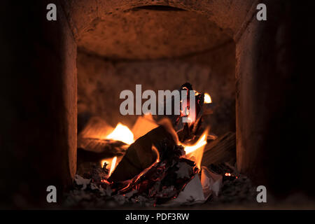 La masterizzazione di carta all'interno del forno di innesco di fiamma di legna da ardere, close-up Foto Stock