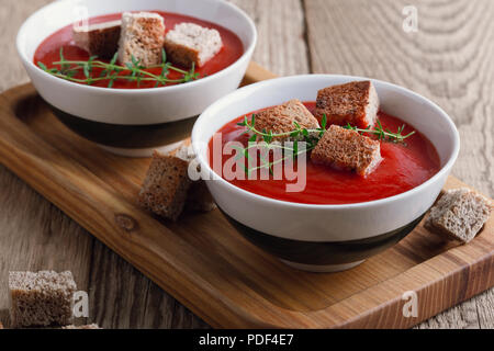 Tradizionale zuppa di pomodoro guarnita con pane di segale di crostini e timo Foto Stock