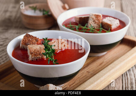 Tradizionale zuppa di pomodoro guarnita con pane di segale di crostini e timo Foto Stock
