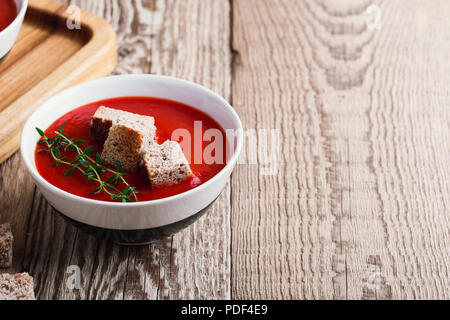 Tradizionale zuppa di pomodoro guarnita con pane di segale di crostini e timo Foto Stock