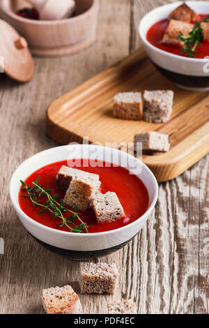 Tradizionale zuppa di pomodoro guarnita con pane di segale di crostini e timo Foto Stock