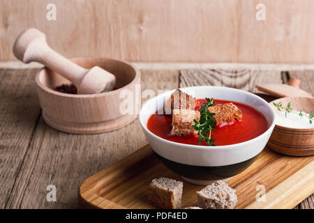 Tradizionale zuppa di pomodoro guarnita con pane di segale di crostini e timo Foto Stock