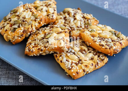 Biscotti di farina di avena con grano e fibra e i dadi. I cookie con grani di dado. Su un piatto di colore grigio. Foto Stock