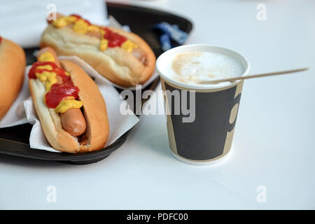 Il DOG, Salsa ketchup, il caffè con il latte in una tazza. Latte isolate su sfondo bianco. Foto Stock