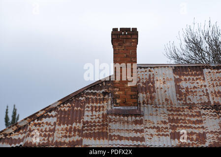 Un vecchio ondulato in ferro zincato tetto e camino in mattoni nel paese del Nuovo Galles del Sud Australia Foto Stock