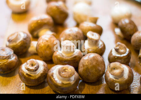 Champignons (Agaricus Bisporus) Champignon de Paris, sulla lastra da cucina pronti per essere cucinati. Foto Stock