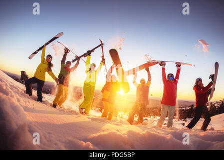 Happy amici alla stazione sciistica divertendosi tramonto Foto Stock