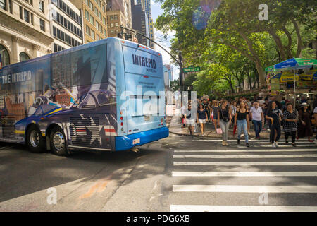 Pedoni cross West 42nd Street come un autobus gira sulla Fifth Avenue nel centro di Manhattan a New York sabato 4 agosto, 2018. (© Richard B. Levine) Foto Stock