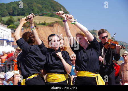 Frusta il gatto Rapper e ostruire, donna inglese del Team di danza, eseguendo un rapper ballo di spada a Sidmouth Folk Festival, East Devon, Regno Unito. Agosto, 2018. Foto Stock