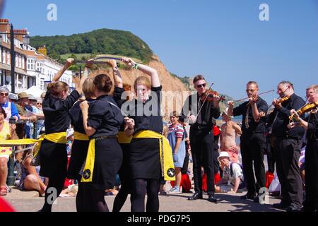 Frusta il gatto Rapper e ostruire, donna inglese del Team di danza, eseguendo un rapper ballo di spada a Sidmouth Folk Festival, East Devon, Regno Unito. Agosto, 2018. Foto Stock