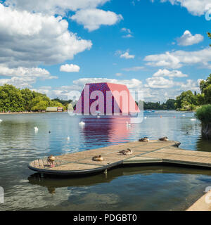 Il 20 metro alto 'Mastaba' scultura dell'artista Christo sul lago a serpentina a Londra. La struttura consiste di oltre 7500 dipinti di barili Foto Stock