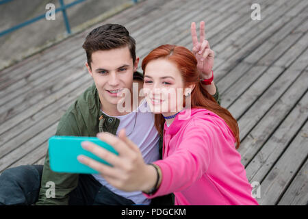 Gioiosa coppia giovane prendendo un selfie dolci ricordi. Foto Stock
