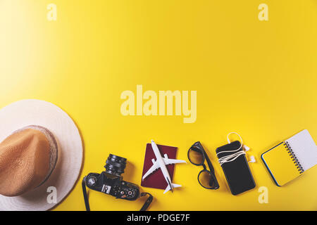 Accessori da viaggio su sfondo giallo con spazio di copia Foto Stock