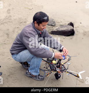 Un uomo dimostra i suoi battenti fotocamera remota drone Foto Stock