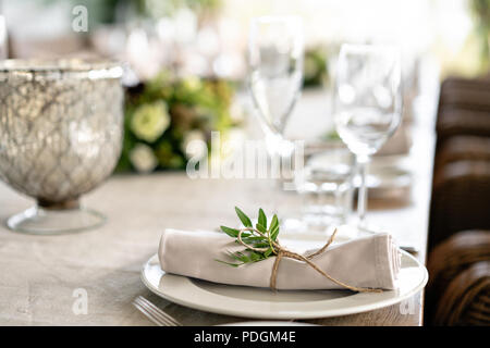 Ordinatamente intrecciati in un tubo sala da pranzo igienico decorate con un rametto di pistacchio. Banchetti per matrimoni o cene di gala. Il tavolo e sedie per gli ospiti, Servita con posateria e stoviglie. party sulla terrazza Foto Stock