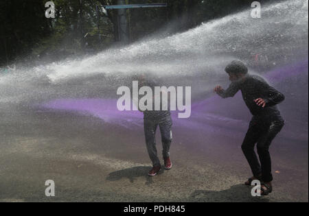 (180809) -- SRINAGAR, e il Agosto 9, 2018 (Xinhua) -- la polizia indiana utilizzare acqua colorata cannon per disperdere i manifestanti a Srinagar, capitale estiva di Indiano-Kashmir controllata, e il Agosto 9, 2018. (Xinhua/Javed Dar)(rh) Foto Stock