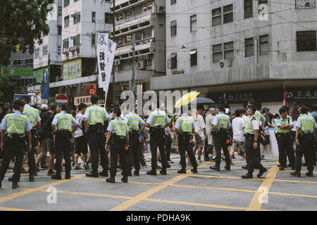 Hong Kong, Hong Kong. 1 Luglio, 2017. La polizia visto il monitoraggio di migliaia di manifestanti hanno marciato.migliaia si sono riuniti e hanno dimostrato in occasione del ventesimo anniversario dell'Handover dalla Gran Bretagna alla Cina, il ritorno di Hong Kong alla Cina il 1 luglio 1997. I manifestanti hanno marciato attraverso il sole e la pioggia da Victoria Park di Admiralty, una presa di posizione su una varietà di diritti umani relative cause. Credito: Viola Gaskell/SOPA Immagini/ZUMA filo/Alamy Live News Foto Stock