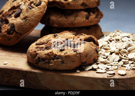 Biscotti al cioccolato sul tavolo rustico. I biscotti al cioccolato e i biscotti con fiocchi di avena o farina di avena Foto Stock