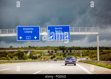 Overhead blu autobahn segno che puntano a un incrocio verso Lipsia e Berlino in Germania Foto Stock