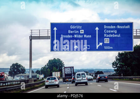 Overhead blu autobahn segno che puntano a un incrocio verso Dresda e Berlino in Germania Foto Stock