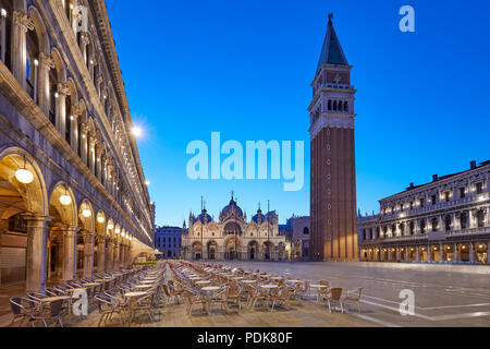 Piazza San Marco illuminata la mattina presto, svuotare i tavoli e le sedie in Italia Foto Stock