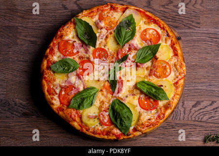 Pizza con prosciutto e patate servita il basilico Foto Stock