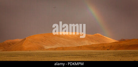 Rainbow brilla su di una duna di sabbia nel deserto in Namibia Foto Stock