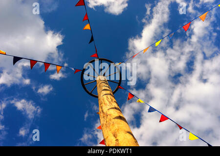 Bandiere a fune per la ruota su un palo nel cielo in fiera Foto Stock