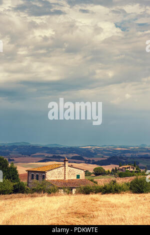 Rustico vecchia casa nelle colline della Toscana con fieno in pendenza. Italia Foto Stock
