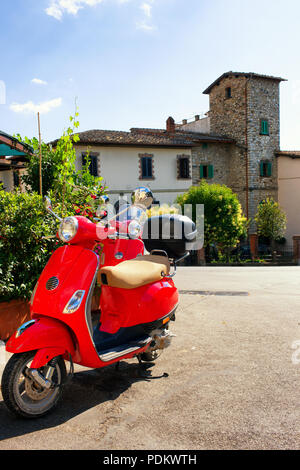 Red scooter e una vite sulla piazza in Toscana in estate in una giornata di sole Foto Stock