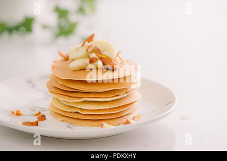 Banana anacardi pancake con banane e salsa al caramello. alla tonificazione. messa a fuoco selettiva Foto Stock