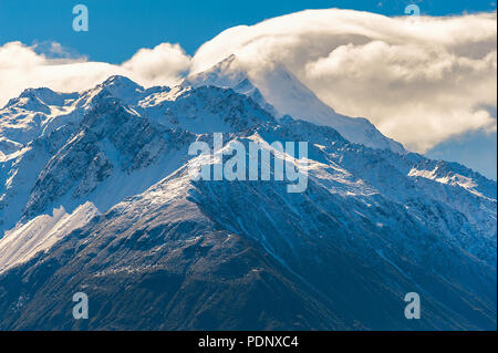 Cime coperte di neve e cloud. Nuvola grande passa sopra la montagna coperta di neve a Mount Cook, Nuova Zelanda. Foto Stock