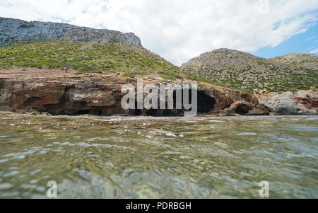 Una grande caverna sul litorale con diverse aperture al mare, visto dalla superficie di acqua, Cova Tallada, Mediterraneo, Costa Blanca, Javea, Spagna Foto Stock