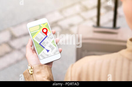 La donna la navigazione con il cellulare mappa di applicazione. Turistico con itinerario a piedi sulla schermata dello smartphone. Viaggiatore con bagaglio tramite GPS. Foto Stock