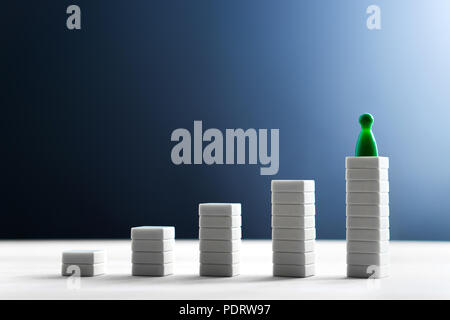 Successo nel business, raggiungendo gli obiettivi principali ed essendo il miglior concetto. Arrampicata e piedi sulla cima più alta. Grafico crescente e schema. Foto Stock