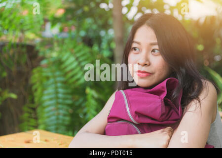 Carino donna asiatica fantasticando guardando al futuro e al sorriso Foto Stock