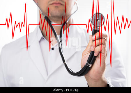 Close-up di un medico che la mano che tiene la frequenza cardiaca con uno stetoscopio Foto Stock