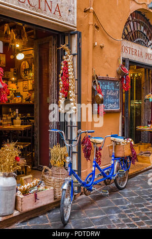 Roma, Italia - 13 ottobre 2016: Antica bici tandem decorata con grappoli di peperoni e aglio di fronte ad un ristorante osteria su un acciottolato medievale Foto Stock