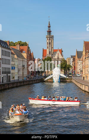 I turisti in un canal tour in barca la visualizzazione di Bruges Balena in plastica scultura realizzata da scartare i contenitori in plastica e rifiuti lavato fino dal mare, Foto Stock