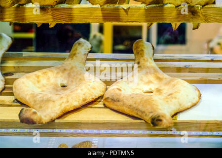 Georgian pane tradizionale - shoti. Il Puri fatti di farina di frumento bianca nel round forno di argilla. Questo pane è sempre sul tavolo con mazzetto di verdi per il georgiano Foto Stock