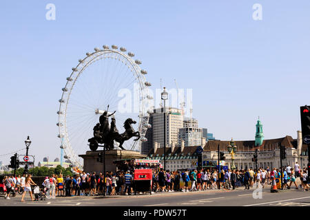 Folle turistiche sul Westminster Bridge con la Coca-Cola London Eye ruota panoramica sulla riva sud del Tamigi, Lambeth, Londra, Inghilterra Foto Stock