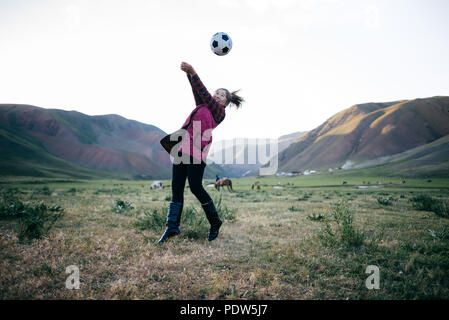 Una ragazza che gioca a pallavolo su un campo in Kirghizistan Foto Stock