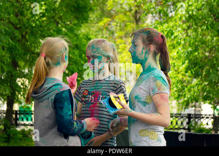 DZERZHINSK, Russia - 19 Maggio 2018: tre giovani ragazze in chat sulla festa di colori e di musica. Facce e capelli decorate con Holi di polvere colorata. Foto Stock