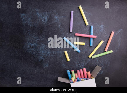Vista superiore del gesso colorato su sfondo Blackboard. Foto Stock